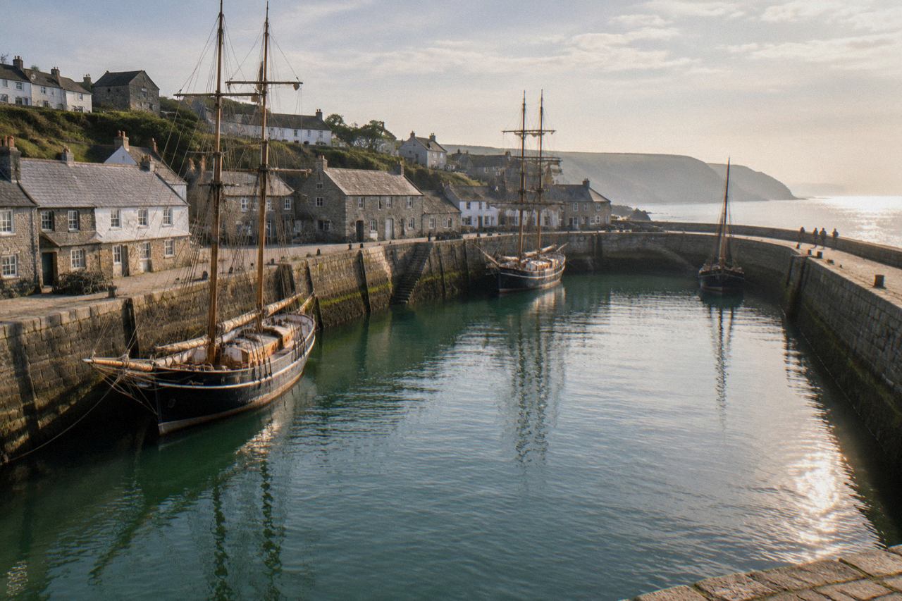 Historic Georgian harbour in Cornwall with stone quays and tall ships in morning light