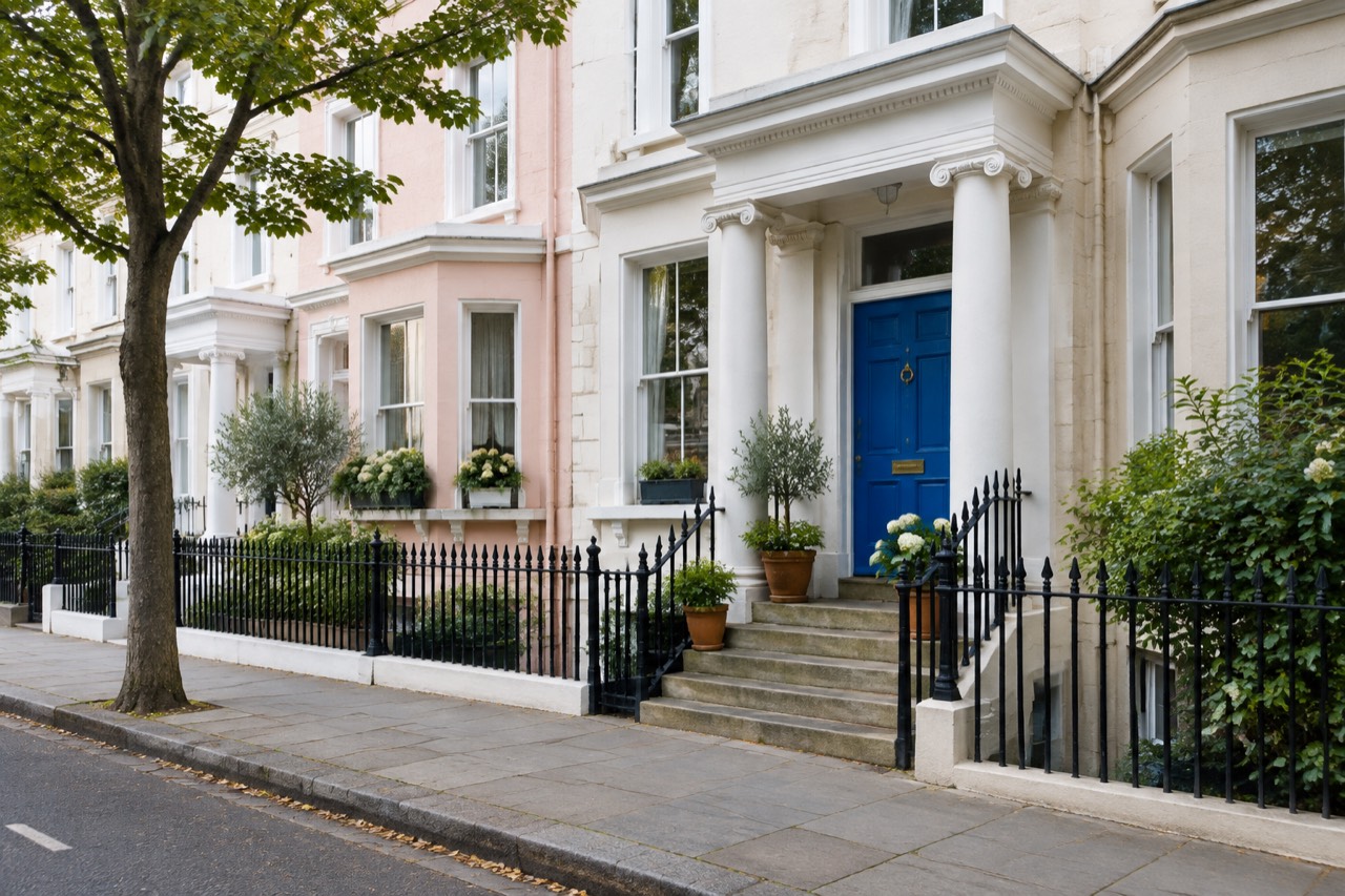 Blue front door on a pastel stucco townhouse in Notting Hill, London.
