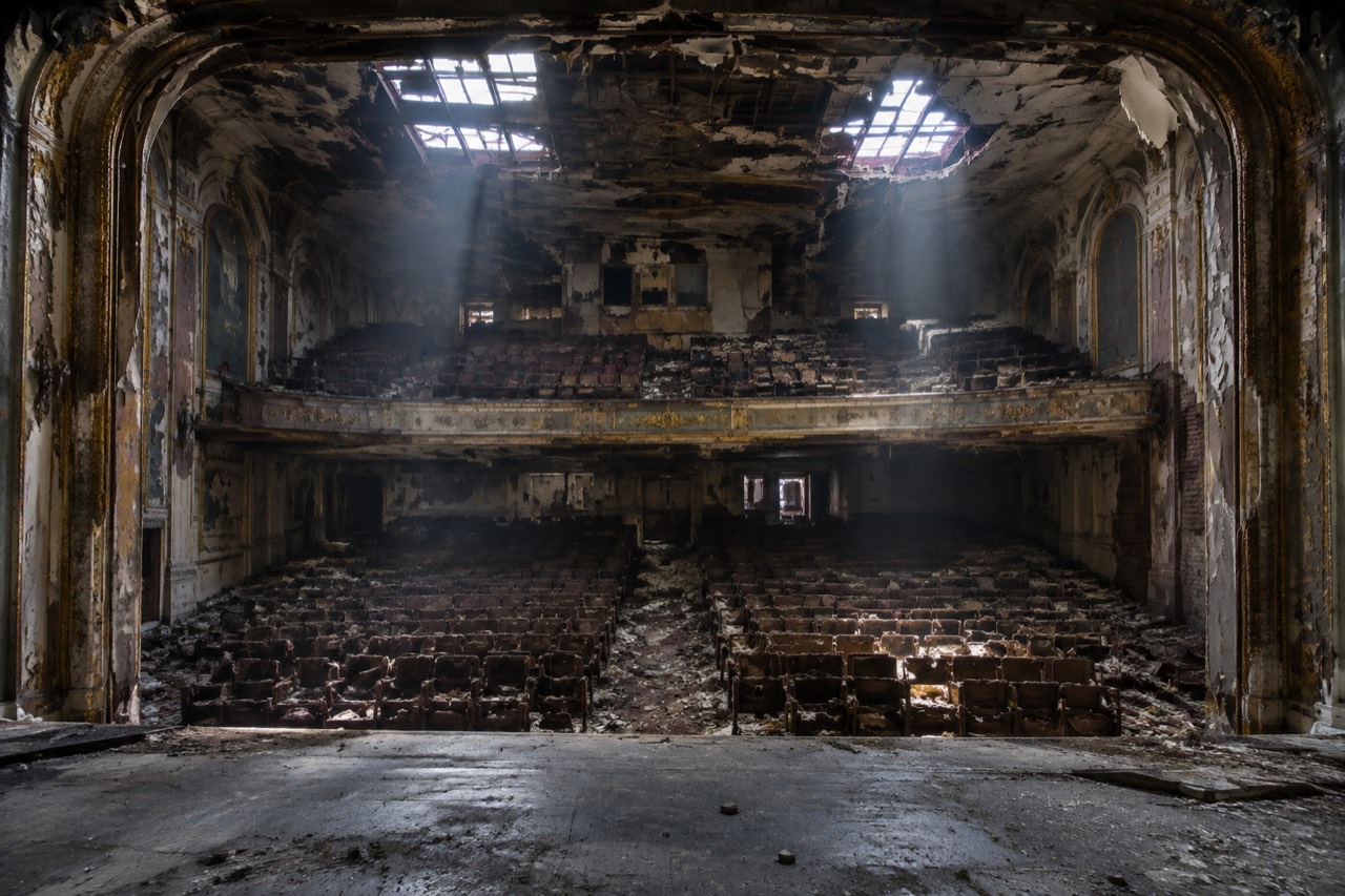 Derelict Brooklyn movie palace auditorium with gutted seats and shafts of daylight