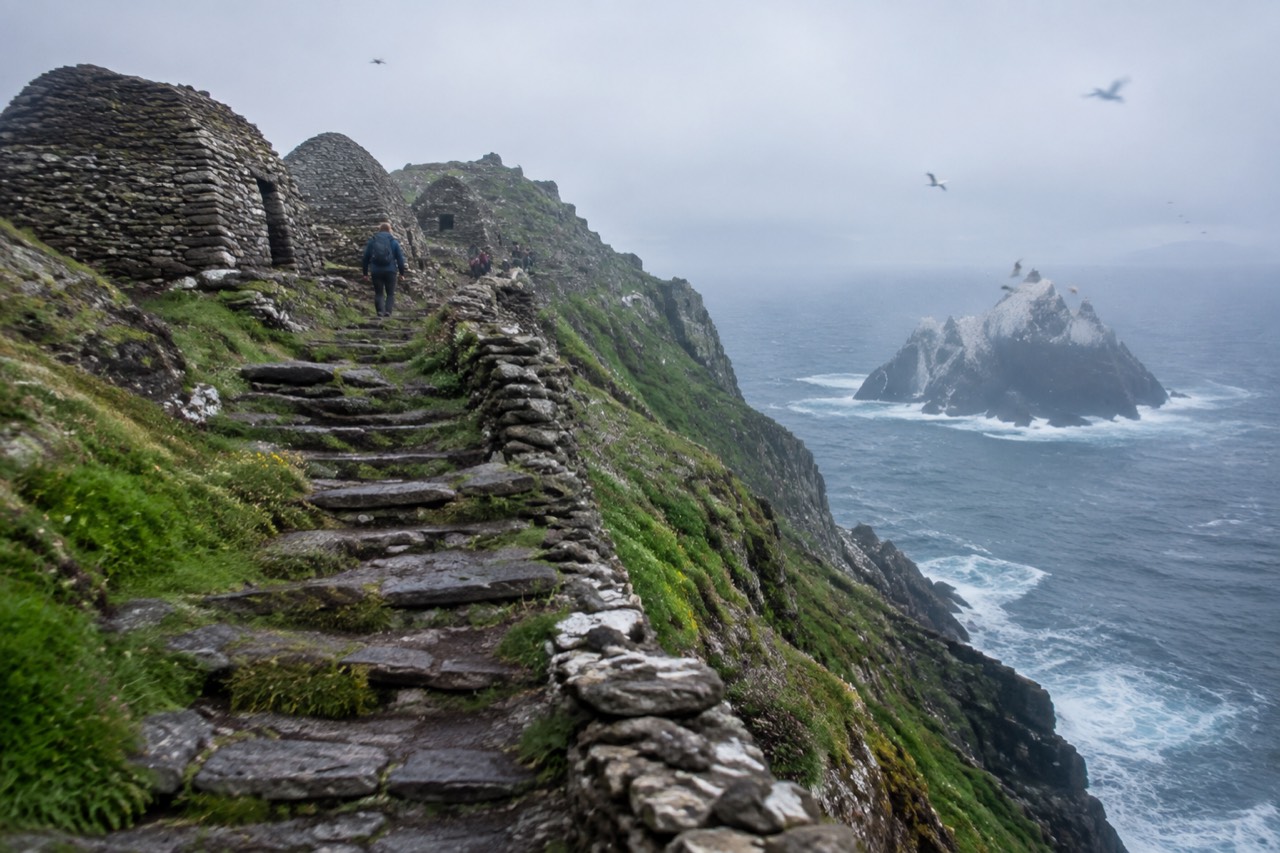 Stone steps and beehive huts on Skellig Michael with gannet-covered islet beyond